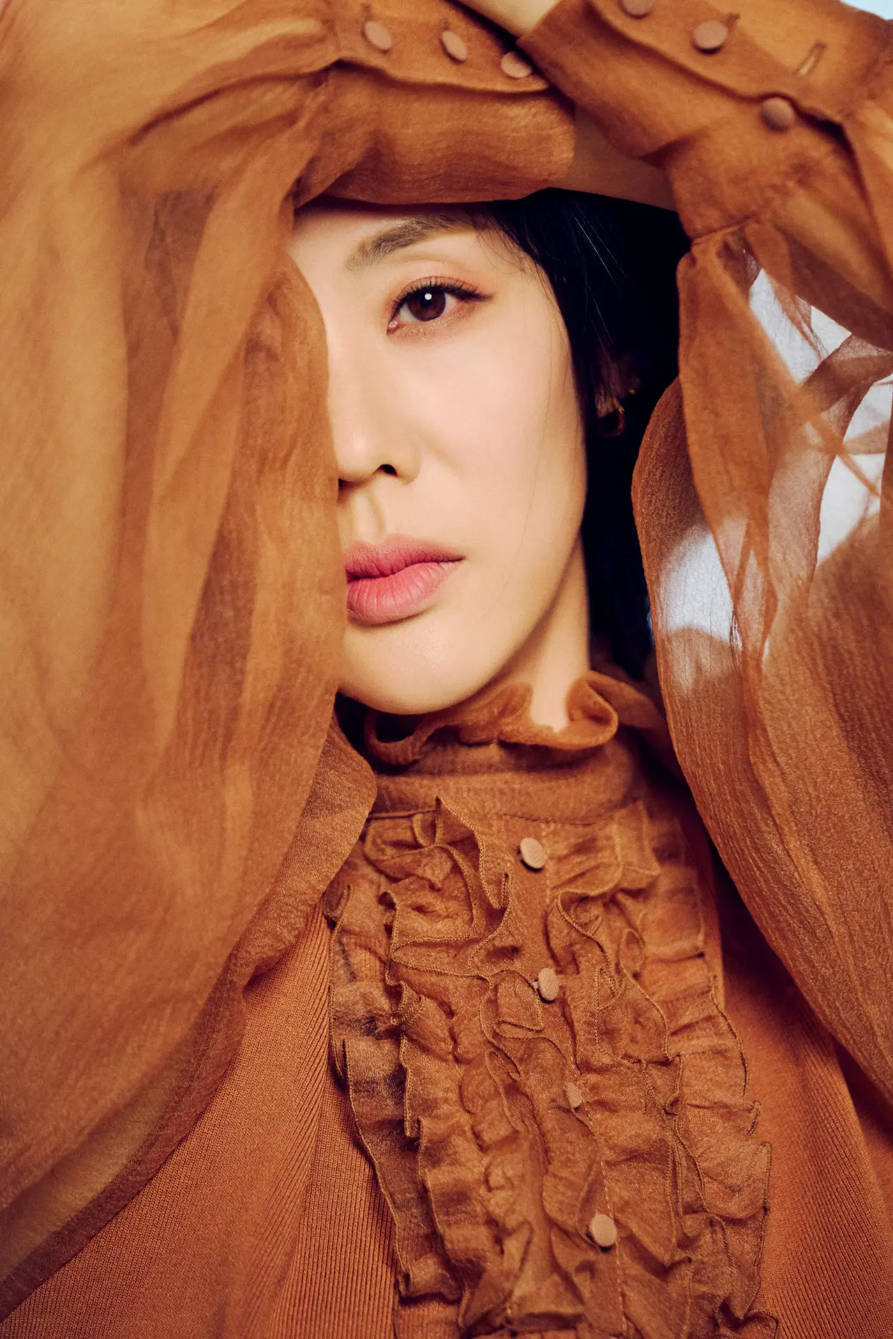 Michelle Jean Kim in a rust silk blouse, close-up beauty portrait